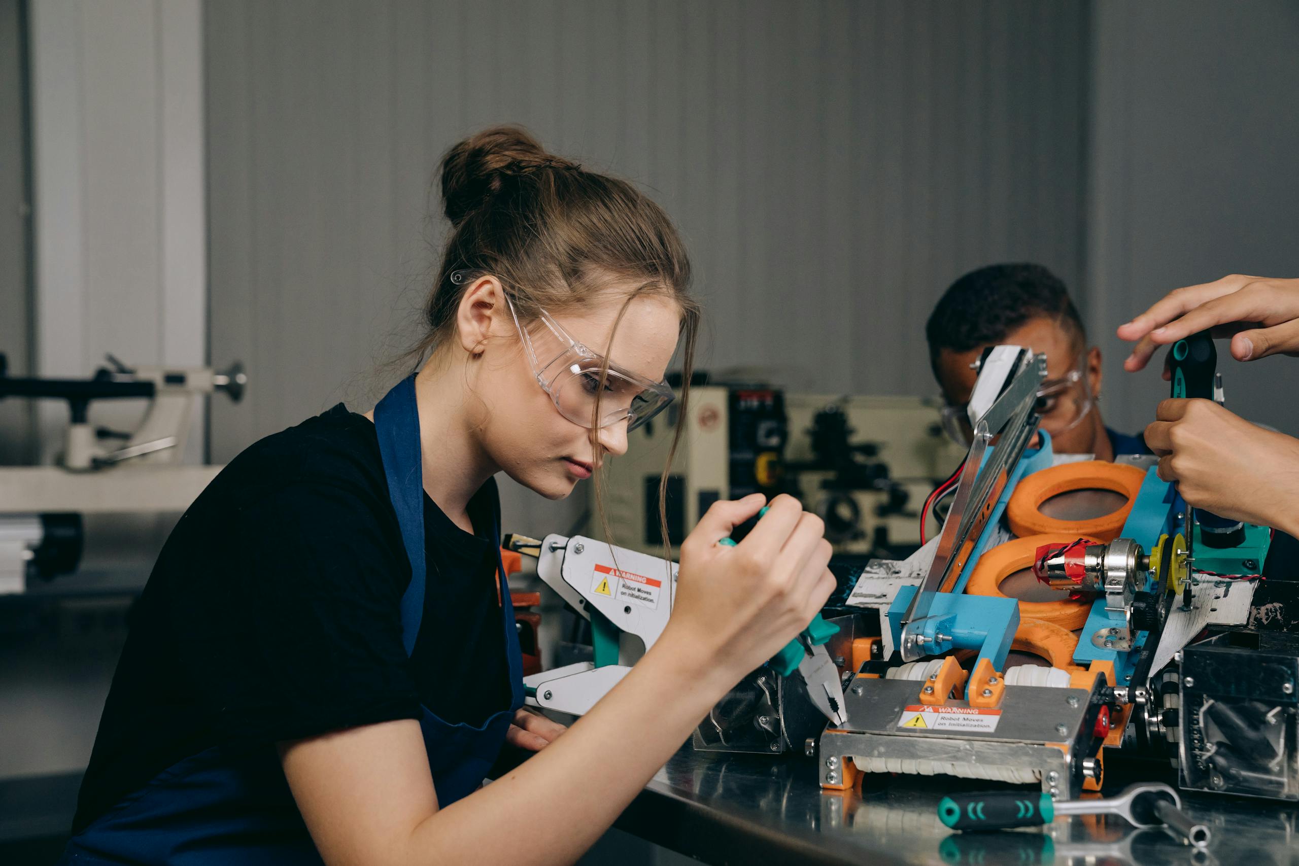 female engineer in a workshop assembling robots with precision tools and safety gear. 9242836 scaled, TAG: Employment and HR Solutions