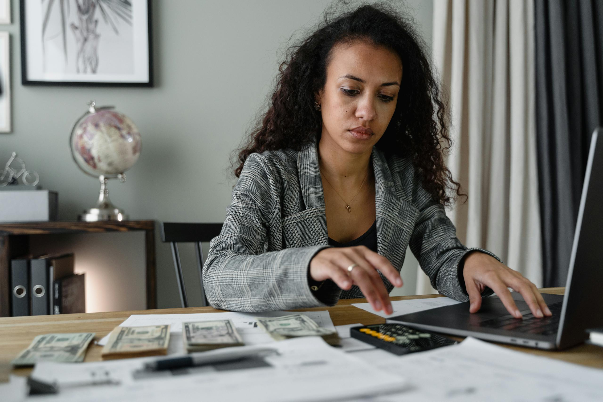 professional woman analyzing financial documents and counting cash at office desk. 6693656 scaled, TAG: Employment and HR Solutions