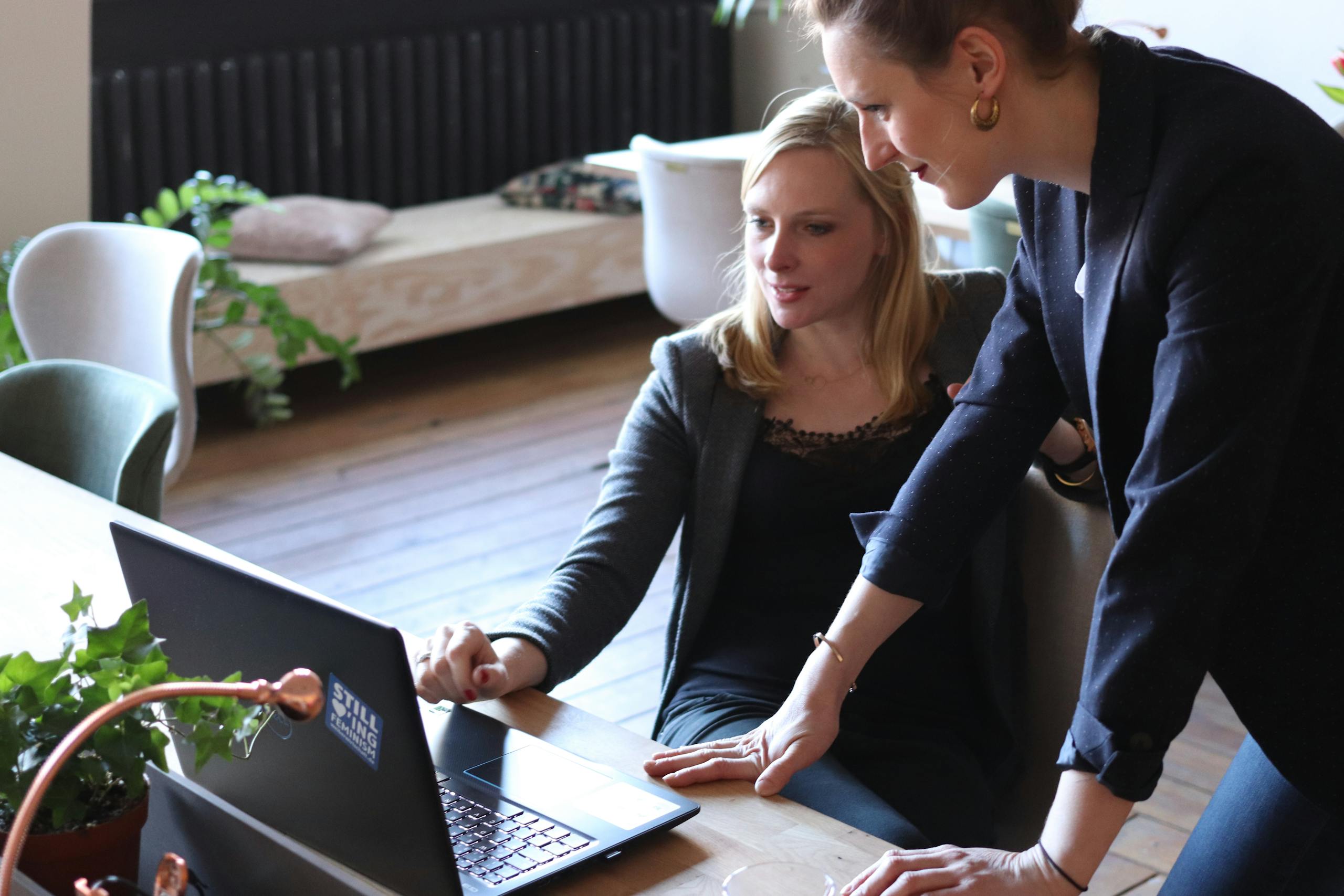 two professional women discuss a project using a laptop in a modern office environment. 2041393 scaled, TAG: Employment and HR Solutions