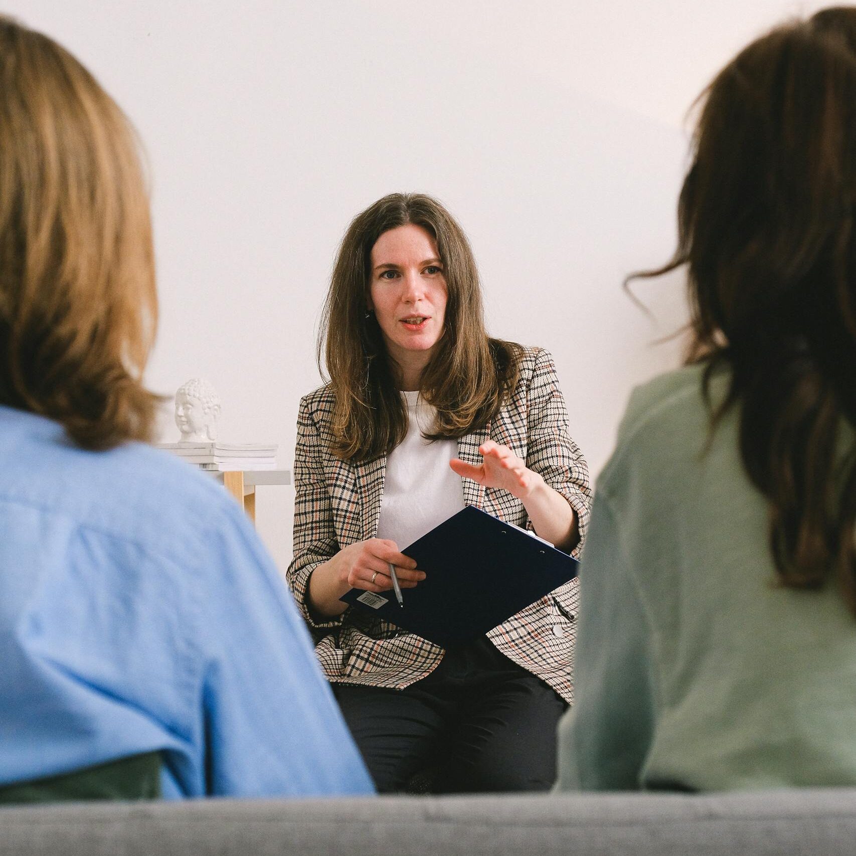 pensive woman entrepreneur with brown hair in casual clothes sitting with clipboard and talking with unrecognizable clients in light room 7176244 scaled e1738946475495, TAG: Employment and HR Solutions